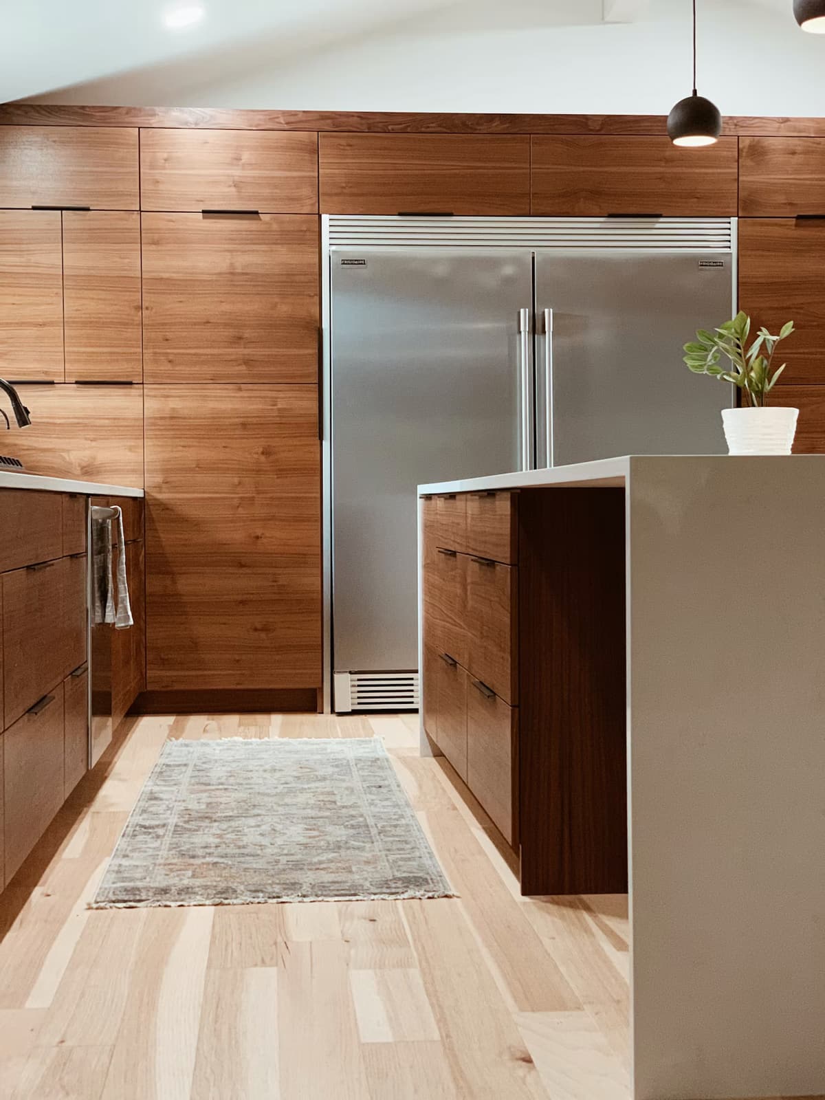 Walnut kitchen with tall custom cabinets and an island